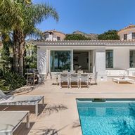 The pool terrace with sun loungers in front of the main house